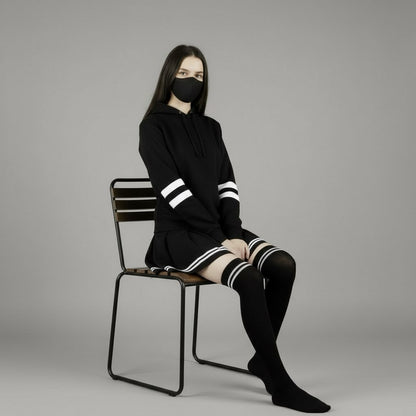 Person wearing a black hoodie with white stripes on a gray background