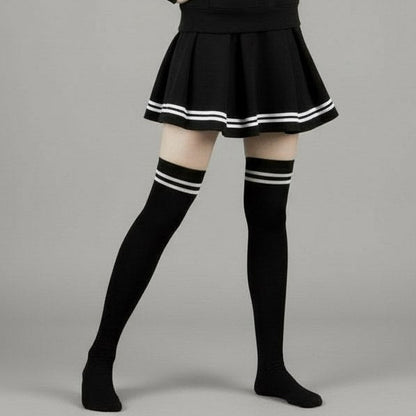 Person wearing a black outfit with white accents on a gray background